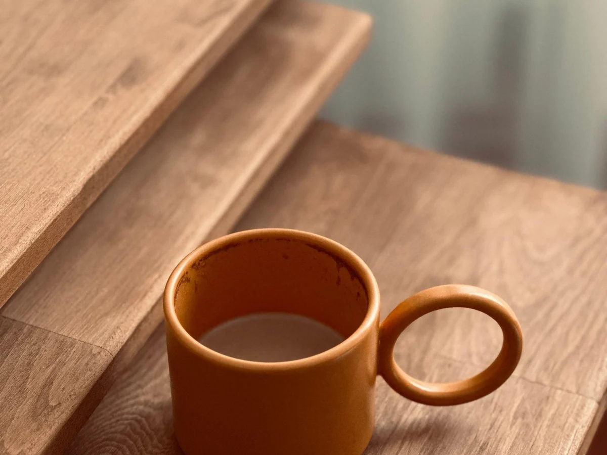 An open ceramic mug showing its rounded rim and circular handle.