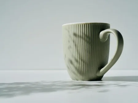 A ribbed ceramic mug with a large curved handle in side view.