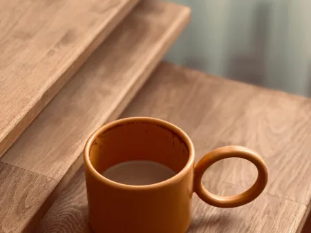 An open ceramic mug showing its rounded rim and circular handle.