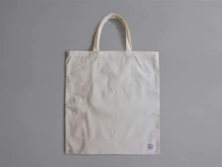 A plain canvas tote with both handles fully visible.